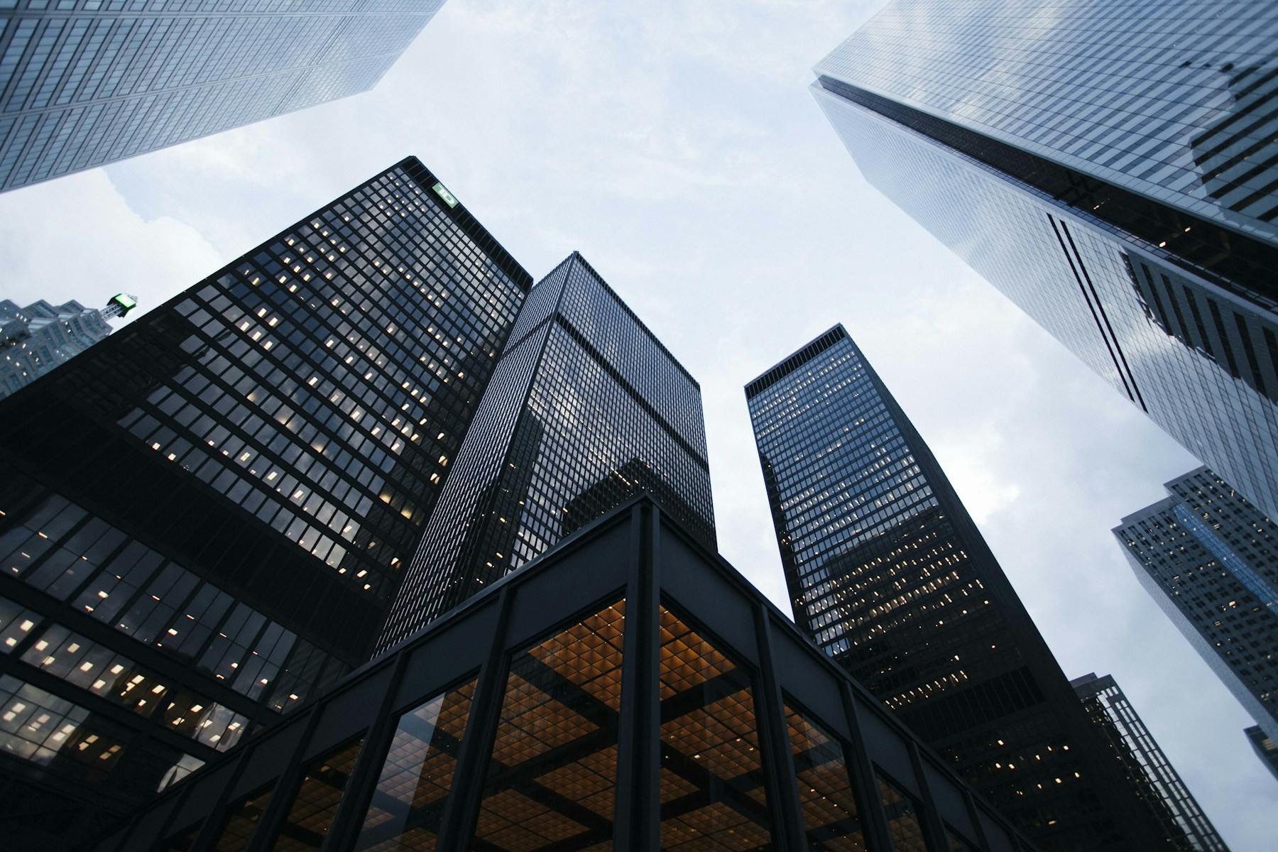 Looking up between contemporary buildings towards an open sky
